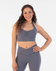 Smiling model showcasing the Chia Halter Neck Sports Bra paired with matching V-waist leggings