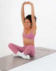 Model stretching in the Raspberry Scoop Bralette on a workout mat