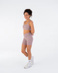 Side view of the Fig Crossover V-Waist Shorts with the model in a relaxed standing pose