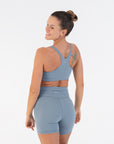 Three-quarter back view of the Juniper Racerback Bra worn by a model